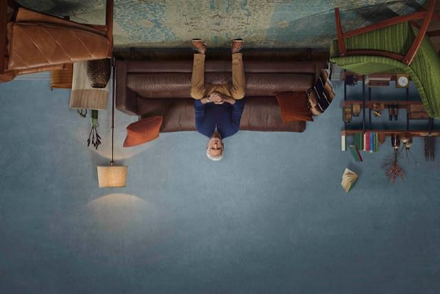 Upside down image of a man on a couch.